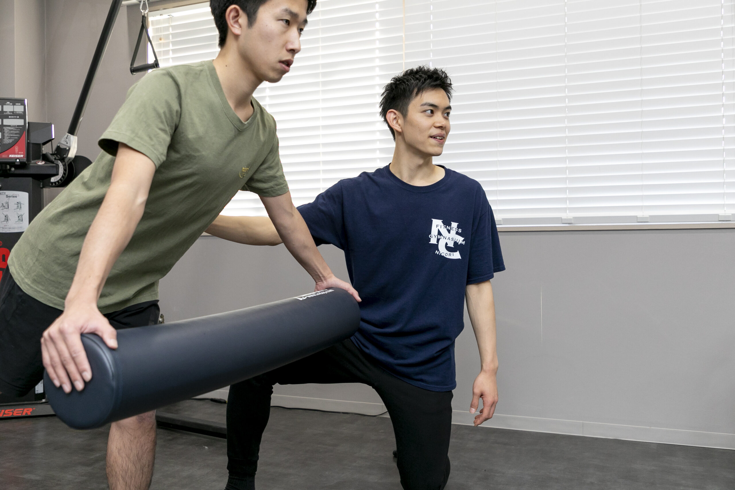 フォーム指導をしている女性トレーナーと笑顔の利用者