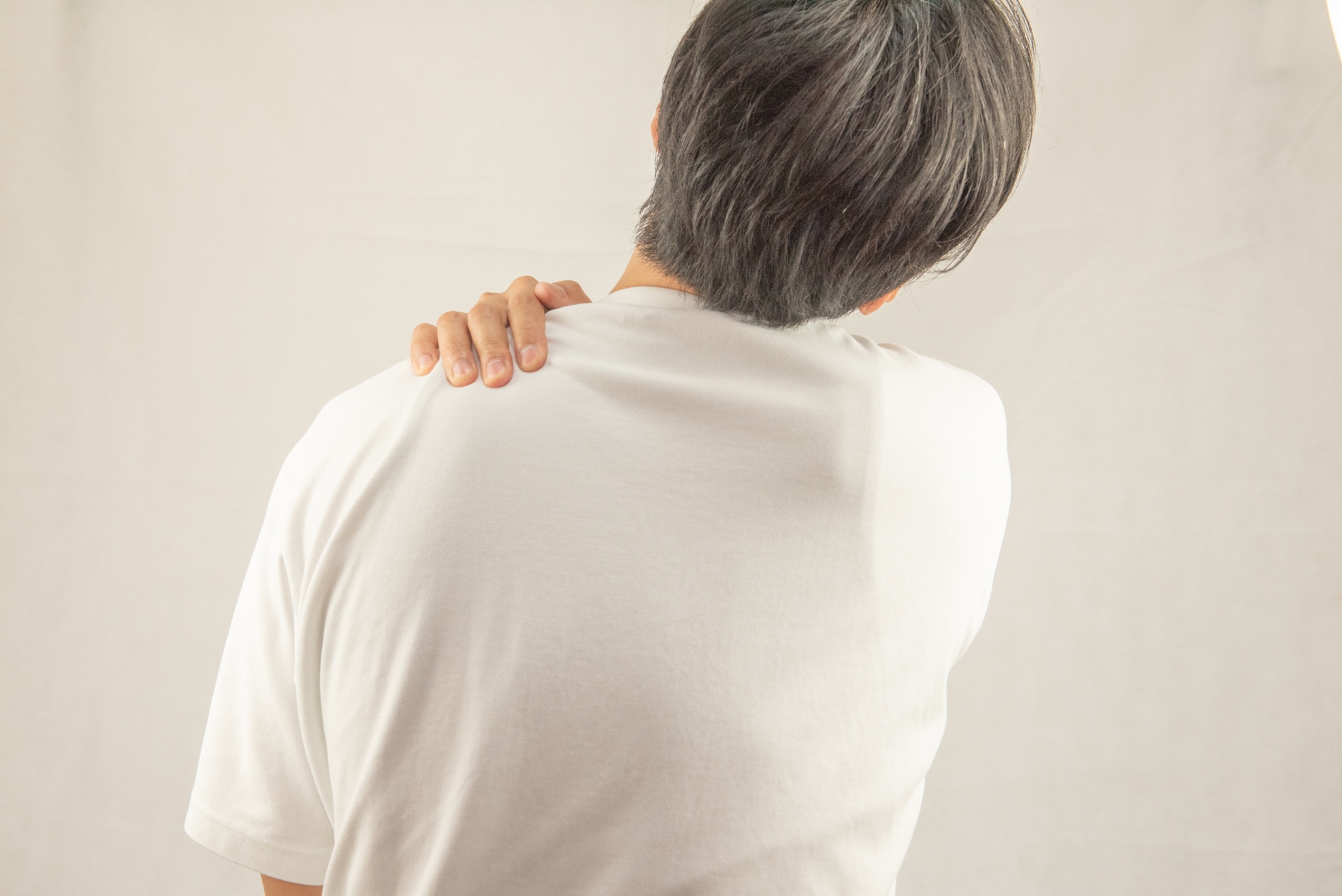 運動後に肩を押さえて不安そうにする女性