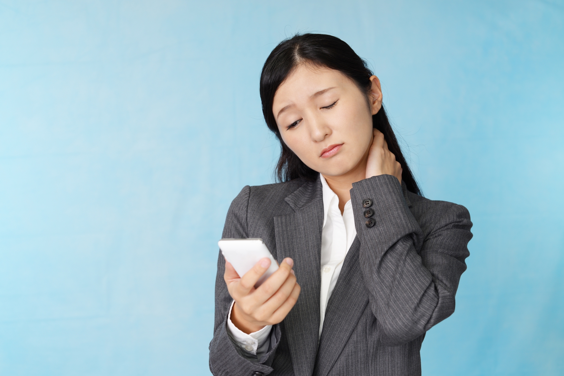 肩こりに悩む女性とスマートフォン