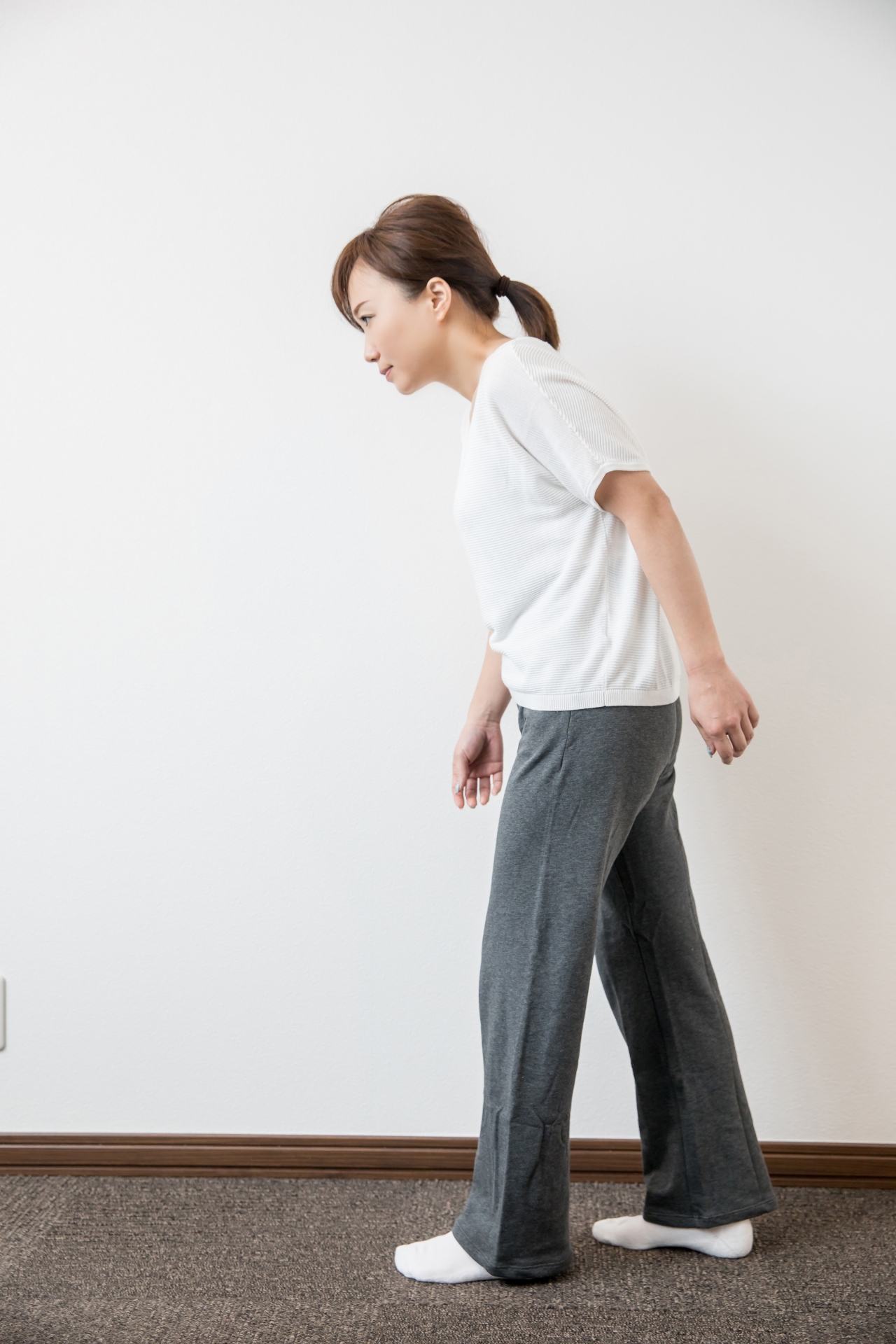 歩き出す前に姿勢をチェックする40〜60代女性。横から見た立位で耳・肩・股関節・くるぶしが一直線に並ぶように確認している場面
